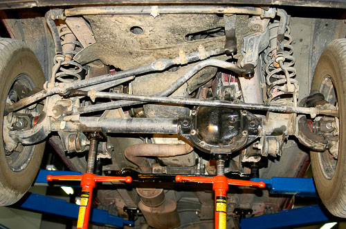 Stock XJ Cherokee suspension with vehicle on hoist.