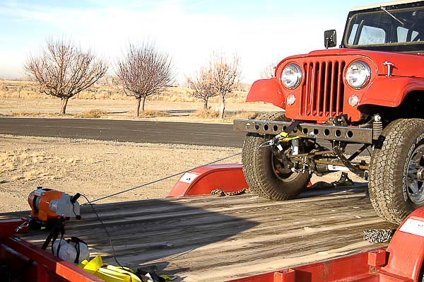 Jeep up on platform deck of trailer.